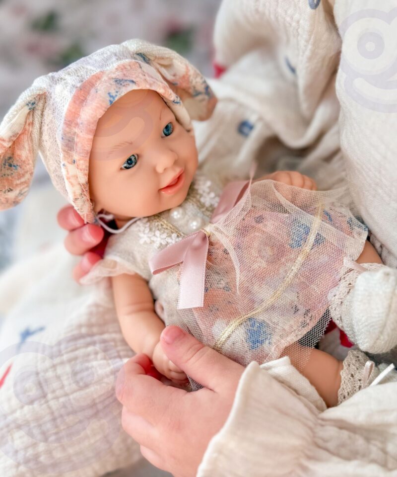 Pastelsetes toonides beebinukk pitsi ja lipsuga