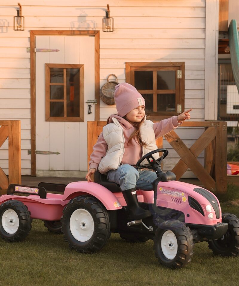 Lapsed mängivad roosa pedaaltraktoriga