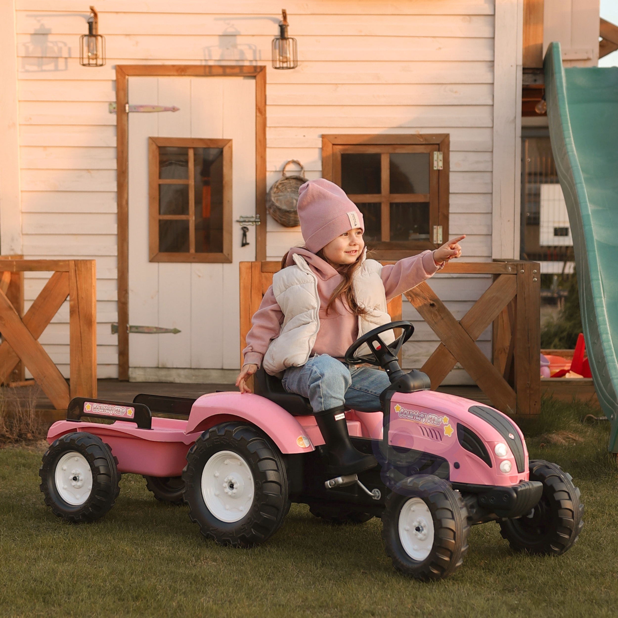 Lapsed mängivad roosa pedaaltraktoriga