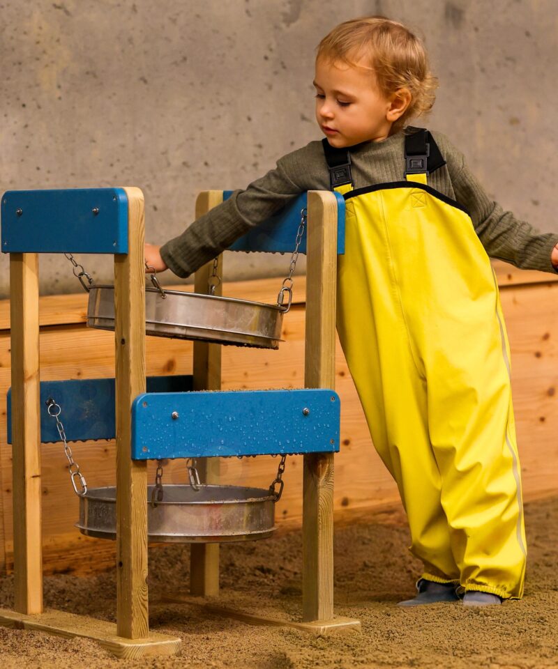 Lapsed mängimas puidust liivakastisõelaga