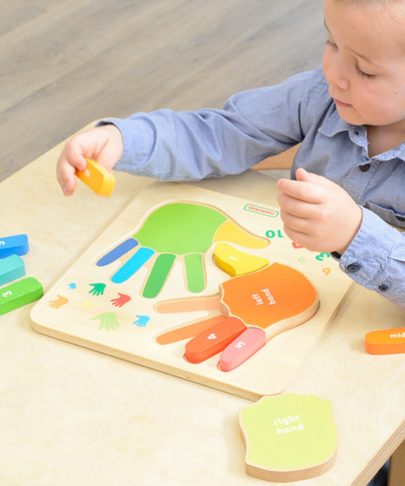 Värvilised käed puidust alusel