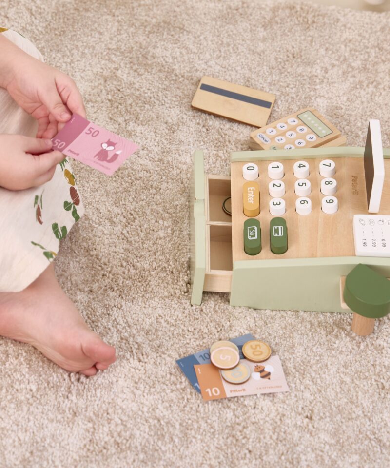 Lapsed mängivad puidust kassaga