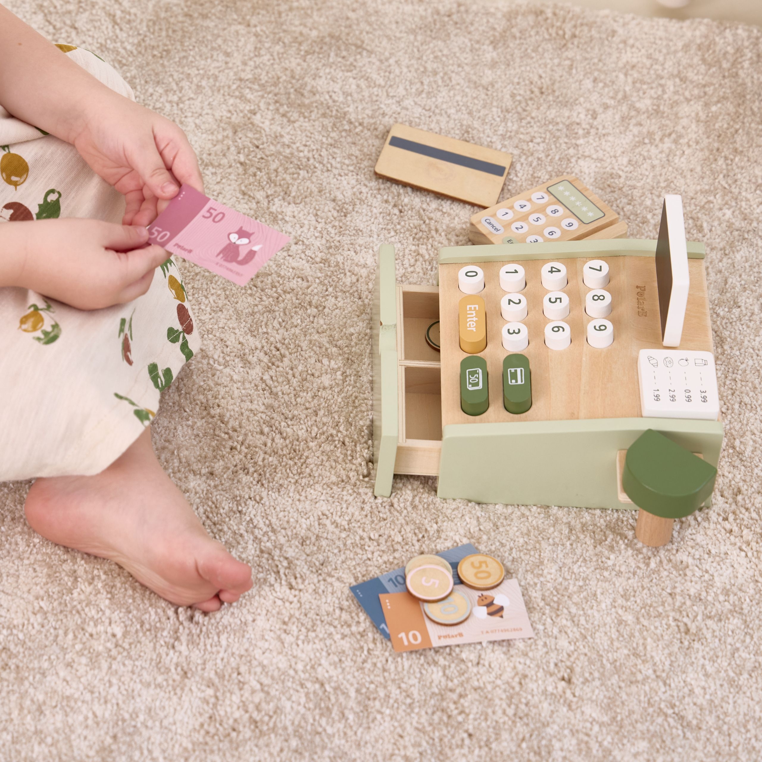 Lapsed mängivad puidust kassaga