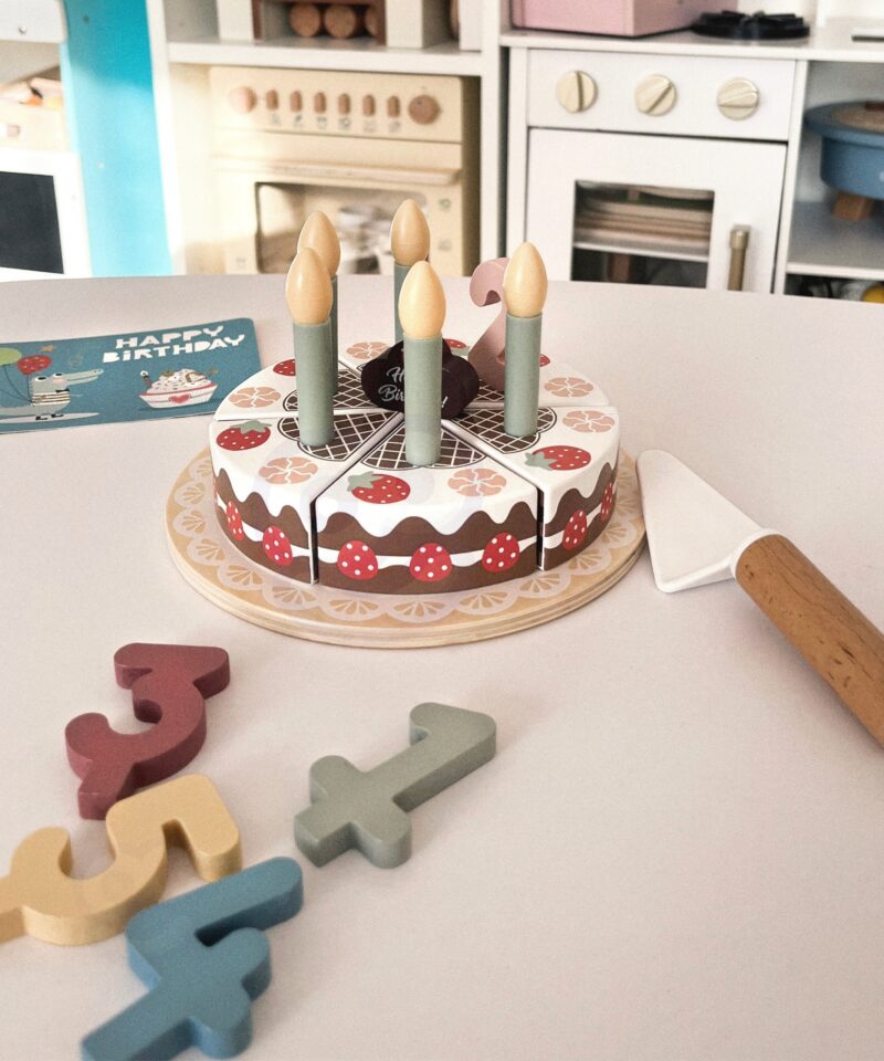 Lapsed mängivad puidust sünnipäevatordiga