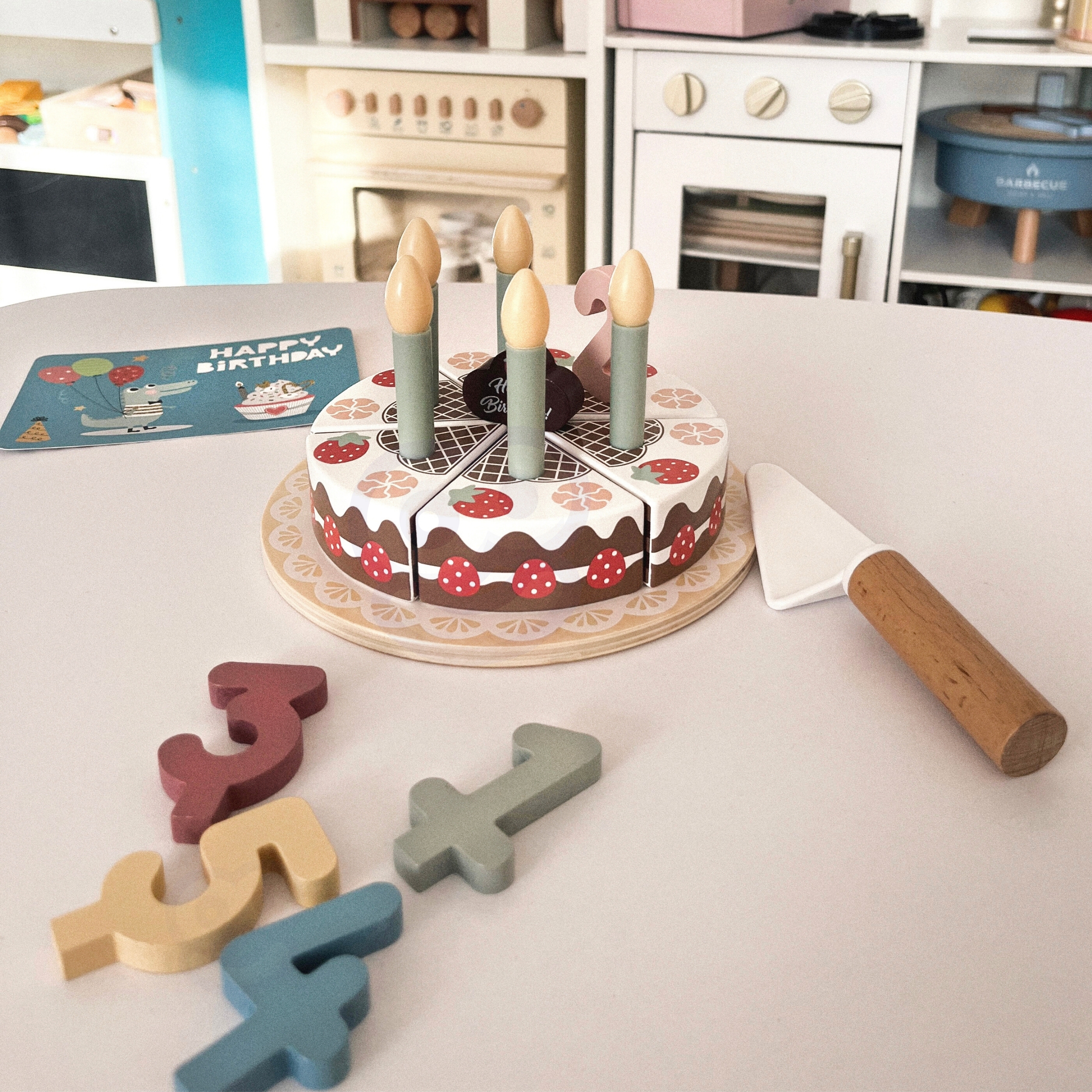 Lapsed mängivad puidust sünnipäevatordiga